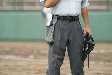 野球の試合中にピッチャーの投球練習を待つ球審