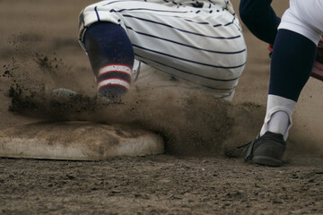 Fototapeta na wymiar 野球の試合中に盗塁を試みてベースに滑り込む野球選手