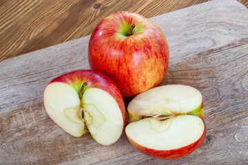red ripe apple on a wooden chopping board