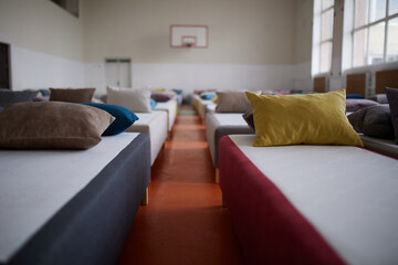 Many multi-colored beds with pillows and linens in the interior of the gym.