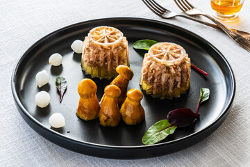 Pork knuckle in jelly and pickled mushrooms on white table
