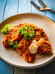 Fish dish - fried fish fillet in vegetable sauce on wooden table
