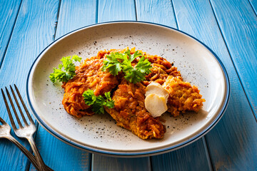Fish dish - fried fish fillet in vegetable sauce on wooden table
