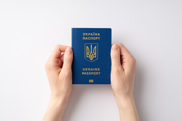 Stop the war in Ukraine concept. Top overhead view photo of female hands holding Ukraine passport on white background
