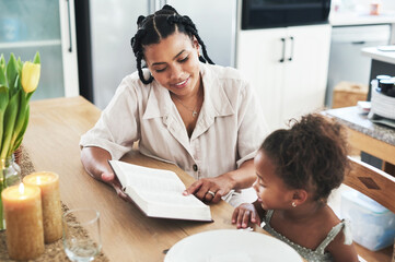 I am not a teacher, but an awakener. Shot of a mother teaching her daughter about the bible at home.