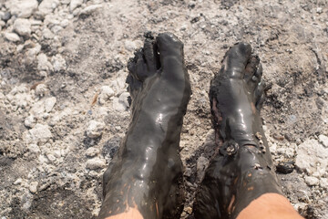 person with rheumatism in the toes doing mud therapy
