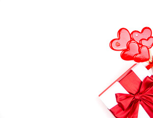 Gift with a bow and candy hearts on a white background. Congratulations, space for text.