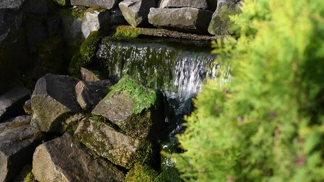 4K video. Amazing mountain spring river flowing in small steps from the upper hill. Nature landscape photography.