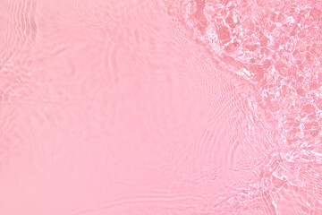 Transparent pink colored clear water surface texture with ripples, splashes and bubbles. Abstract...