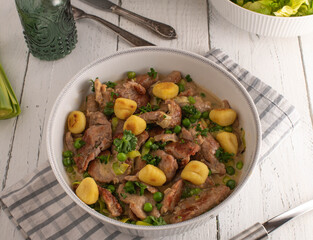 Pork strips with cream sauce, peas-leek and gnocchi