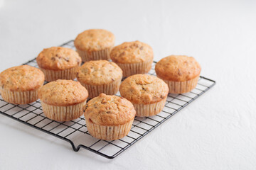 Vanilla fresh baked muffins on a white table with nuts and berries