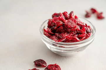 Dried cranberries in glass bowl over bright background