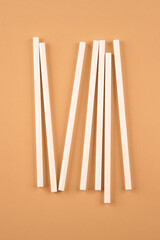 White paper straws on light brown background with copy space. Biodegradable drinking straws. Sustainable lifestyle and zero waste concept
