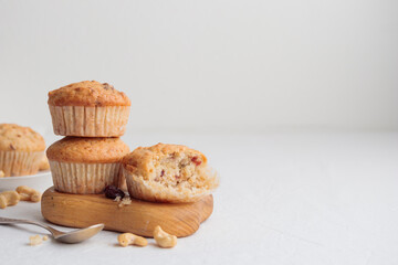 Muffins in a wooden plate on a white table