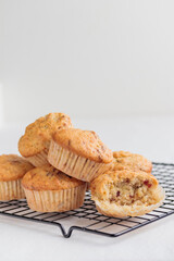 Vanilla fresh baked muffins on a white table with nuts and berries