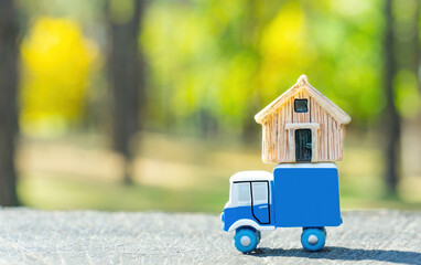 Toy truck with a tiny house on top outdoors - obrazy, fototapety, plakaty