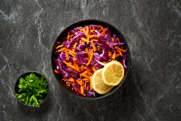 Fresh red cabbage salad, Coleslaw in a bowl on a dark background. Top view. 