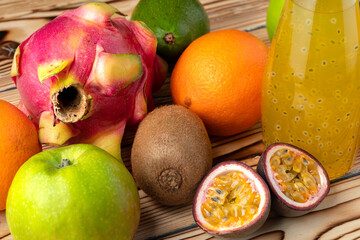 Fruit drink in glass bottle and frsh fruits on wooden background
