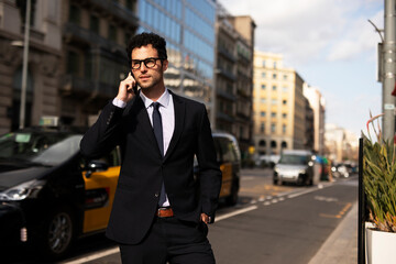 Fototapeta na wymiar Handsome businessman talking to the phone. Young elegance man outdoors..