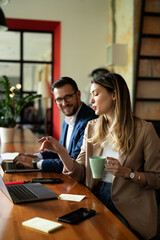Colleagues drinking coffee in office. Businesswoman and businessman discussing work in office..