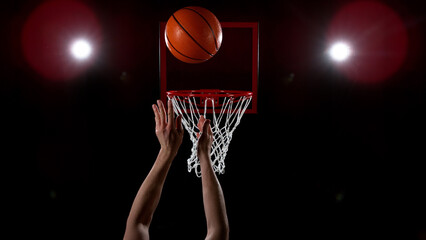 Basketball going through the basket on black backgorund