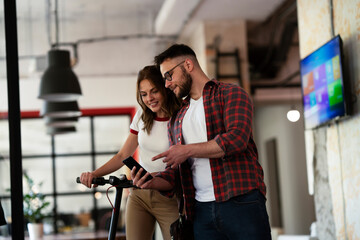 Young businessman and businesswoman in the office. Two friends talking together.