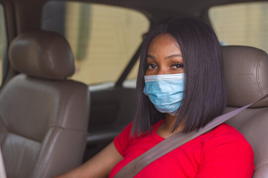 African Lady With A Face Mask Driving Her Car