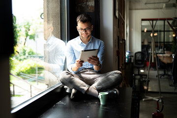 Young businessman using digital tablet in the office. Handsome man learning online..
