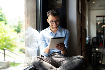 Young businessman using digital tablet in the office. Handsome man learning online..