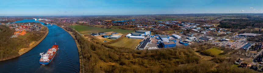 Panoramic aerial view of Kiel Canal with container ships and industrial park. Cargo ships on the...