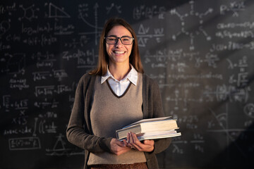 Cinematic shot of young female teacher or student holding books and smiling in camera satisfied...