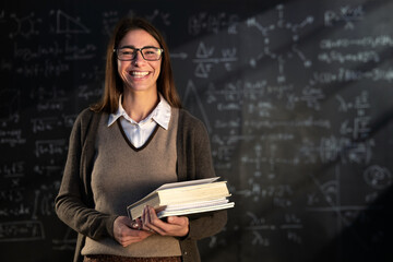 Cinematic shot of young female teacher or student holding books and smiling in camera satisfied...