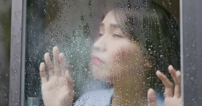 woman behind rainy window