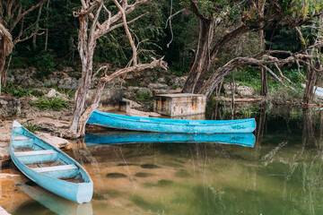 Fototapeta premium Hellblaues Kanu im Wasser in wunderschöner Natur in Mexiko Yucatan