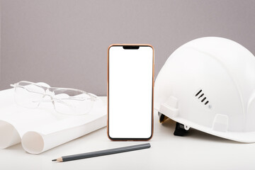 white helmet, smartphone, drawings, plan, pencil on white background, copy space, architectural and construction background