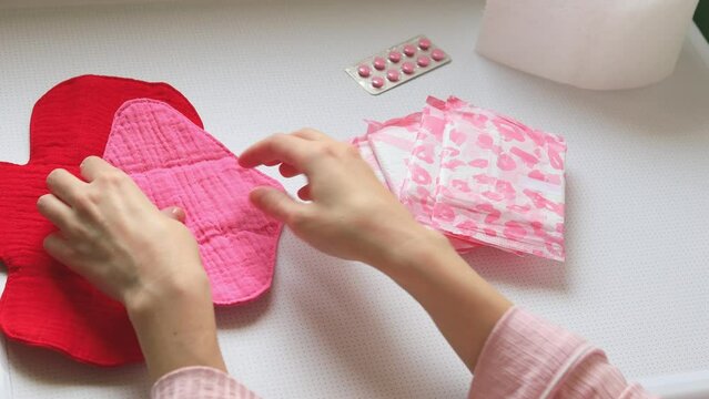 Close-up of a woman choosing disposable or reusable cotton sanitary pads. Alternative ecological feminine hygiene product during menstruation waste-free concept