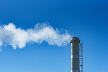 white smoke from industrial pipe against background of blue sky, plant, atmospheric pollution, boiler room