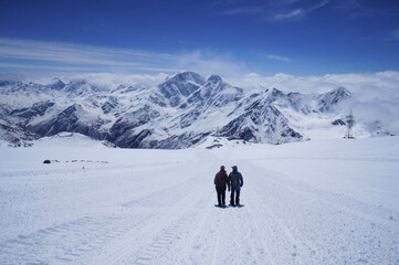 Fototapeta na wymiar Couple of hikers trekking in snow mountains