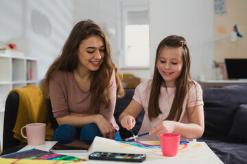 mother and daughter painting picture together