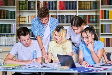 Group of teenage students study in library class.