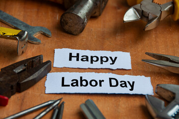 Happy labor day text on torn papers with working tools background. Labor day celebration concept.