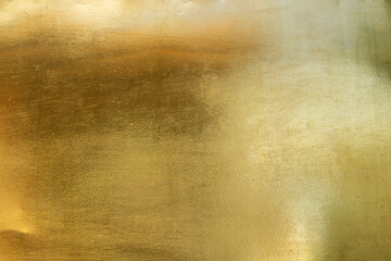 gold foil background with golden textured wall reflection
