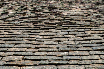 Old stone slade tiles roof closeup as stone background