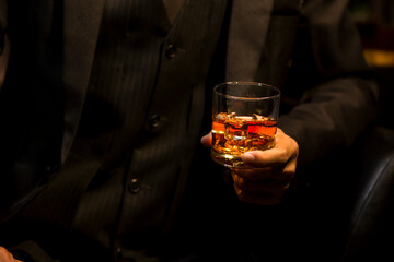 Closeup businessmen holding a glass of whiskey