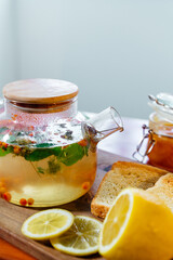 Beautiful glass teapot with sea buckthorn tea. Hot winter drinks