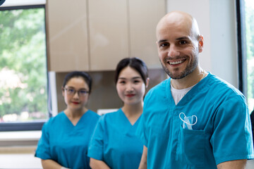 Team of happy stomatologists in dentist's clinic.