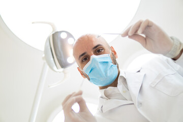 Fototapeta na wymiar Skillful male dentist is treating human teeth