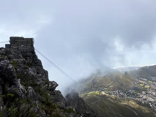 Papier Peint photo Montagne de la Table View of the Table Mountain cable car station from the top on a cloudy day.