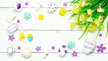 Colorful background with Easter eggs on white wooden board background.