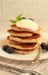 Pile of banana pancakes with cream on top